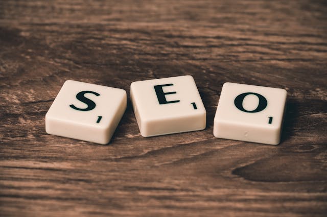 Plastic white cubes spelling out SEO on a wooden surface.